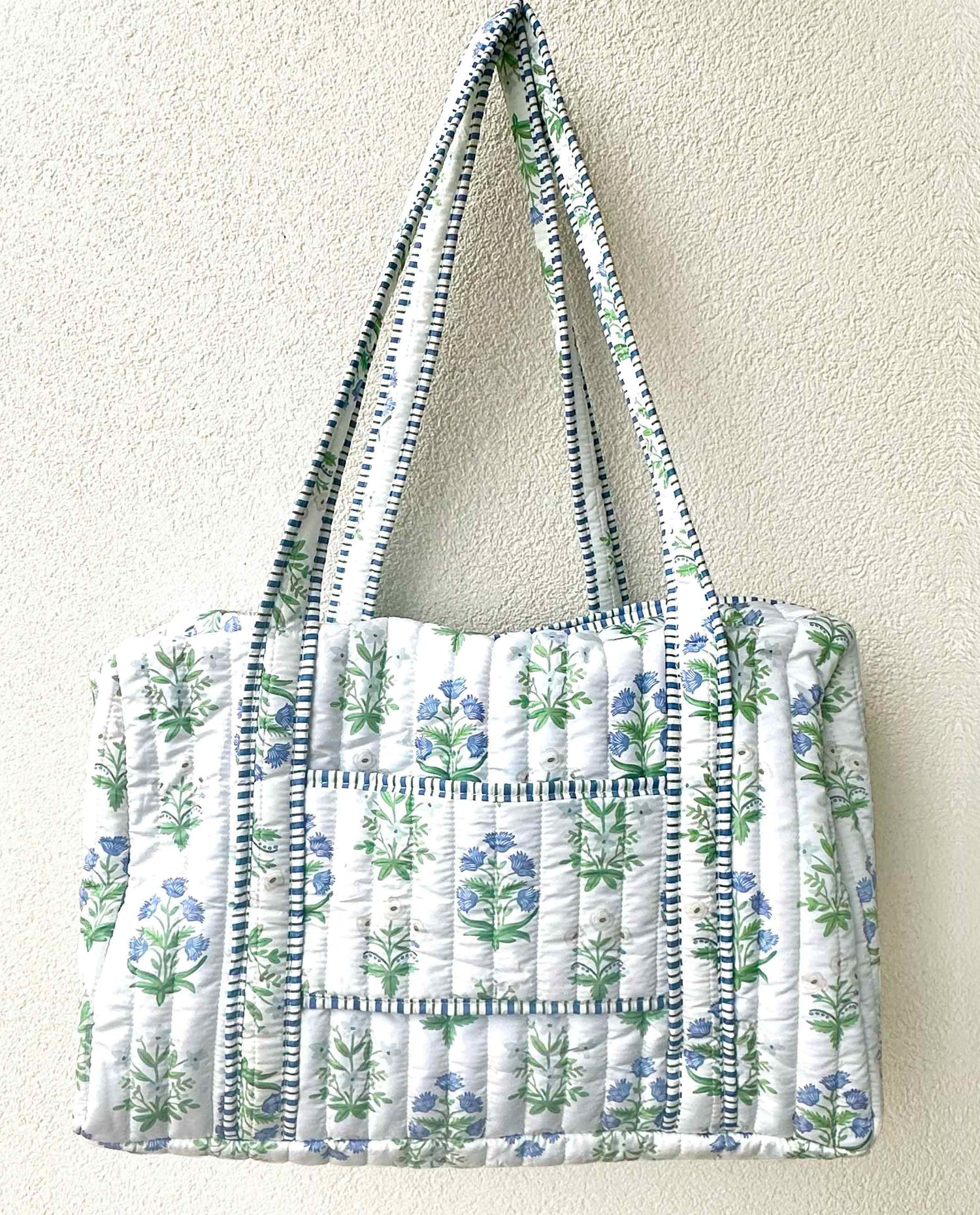 Quilted tote bag with floral pattern on a plain background